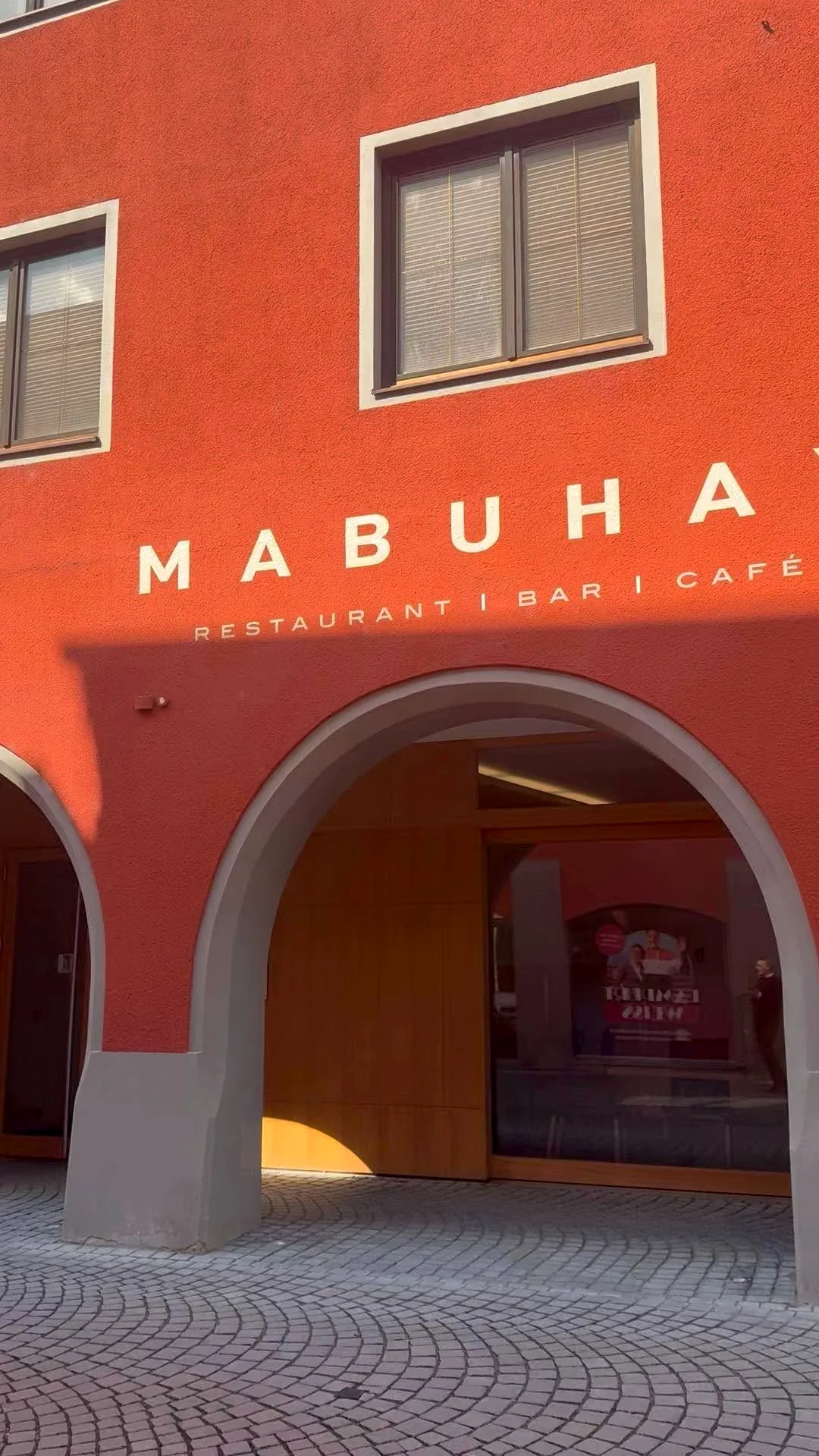 Die rote Fassade des Mabuhay mit dem Rundbogen der Arkaden in der Rathausgasse